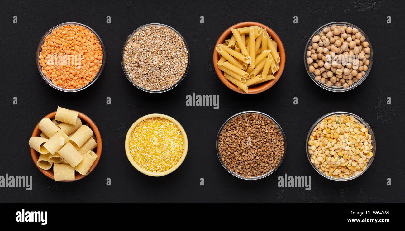 Set of grains and noodles rich on carbohydrates in plates on black