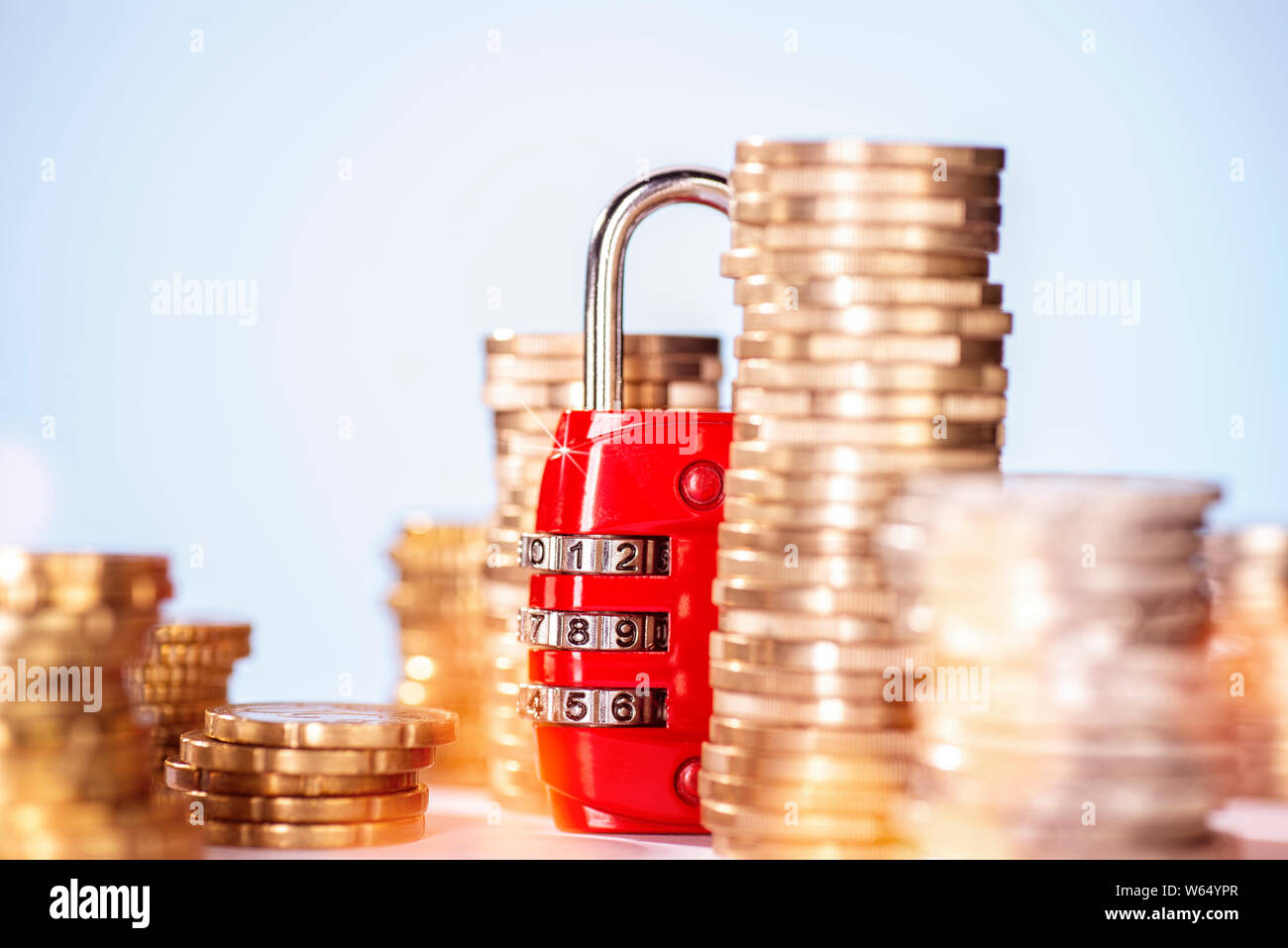 Combination lock with several stacks of coins Stock Photo