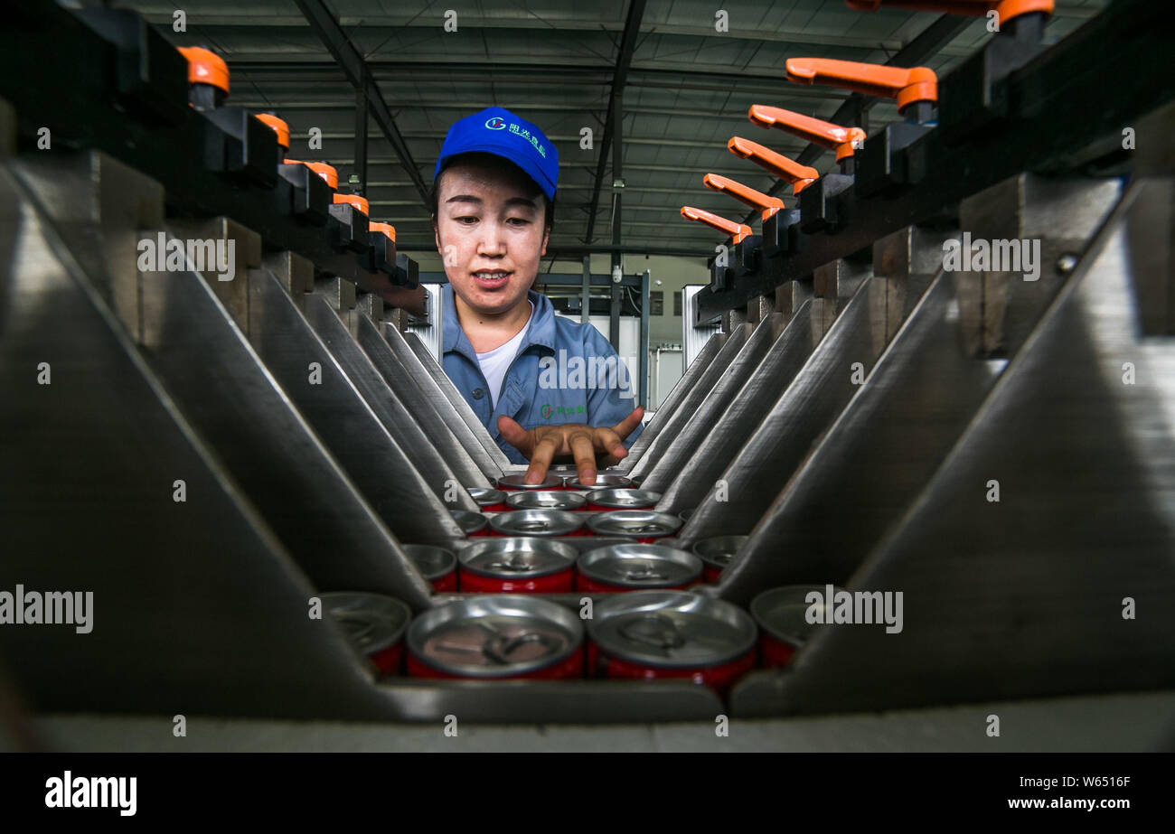 --FILE--A Chinese worker surveys the production of beverage on the ...