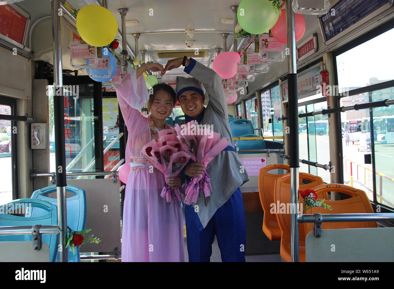The bus driver and his wife pose for a photo on the bus decorated to encourage passengers to share their love with the special person in their life be Stock Photo