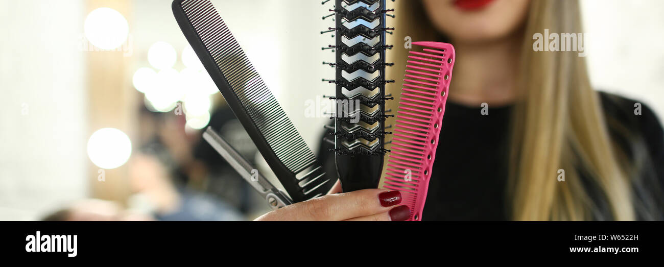 Beautiful Hairdresser Showing Comb and Scissors Stock Photo