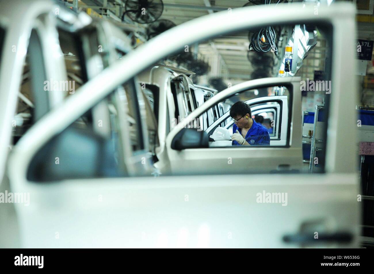 A Chinese worker assembles Wuling Motors on the assembly line at an ...