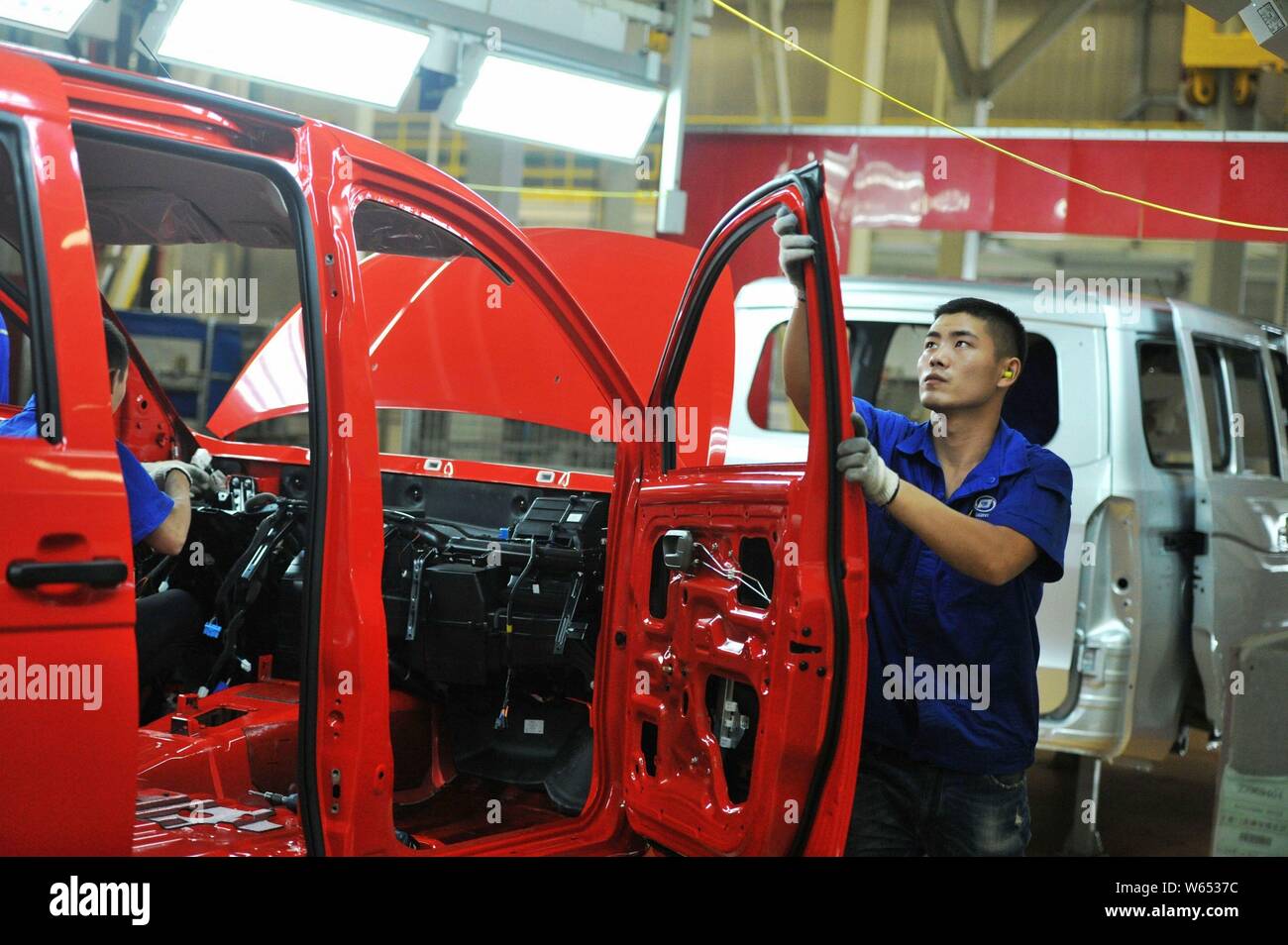 A Chinese worker assembles Wuling Motors on the assembly line at an ...