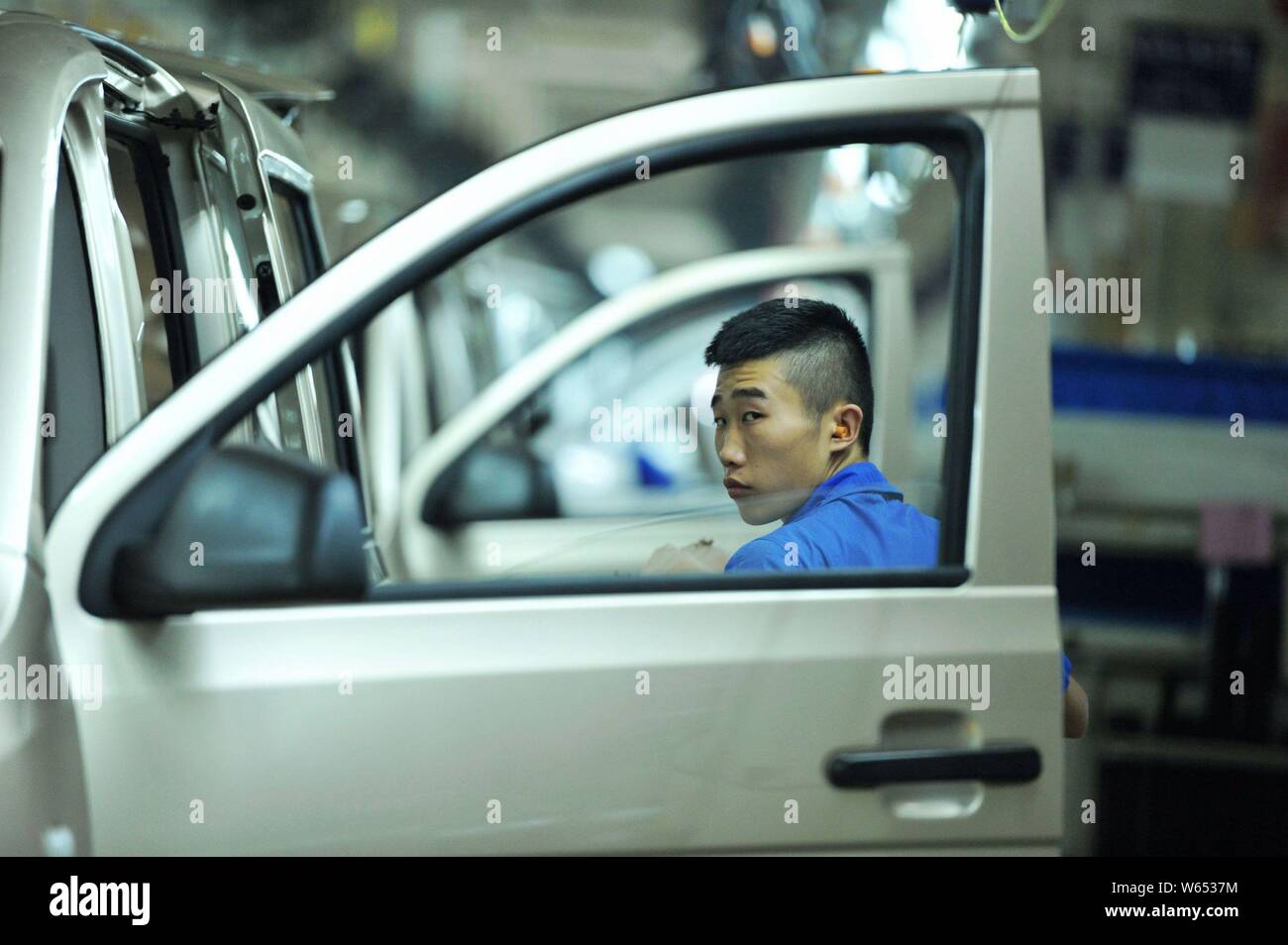 A Chinese worker assembles Wuling Motors on the assembly line at an ...