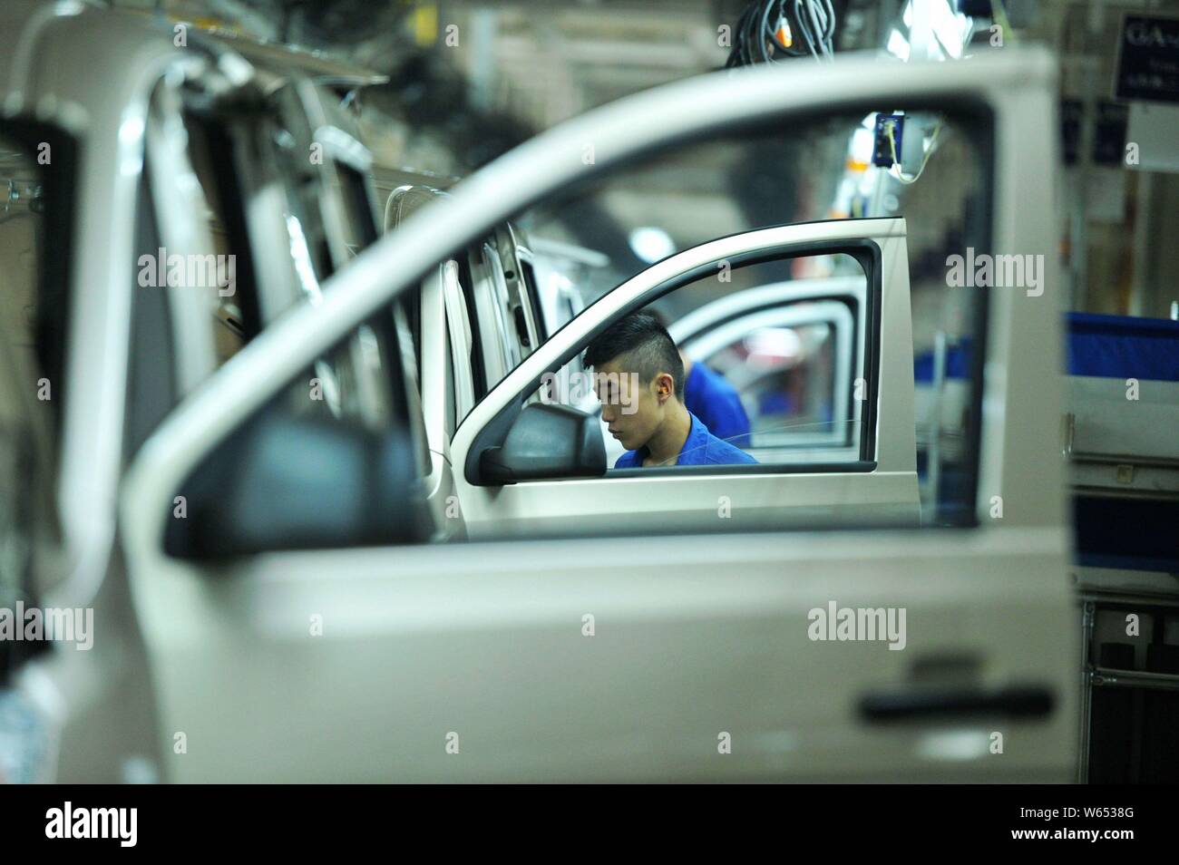 A Chinese worker assembles Wuling Motors on the assembly line at an ...