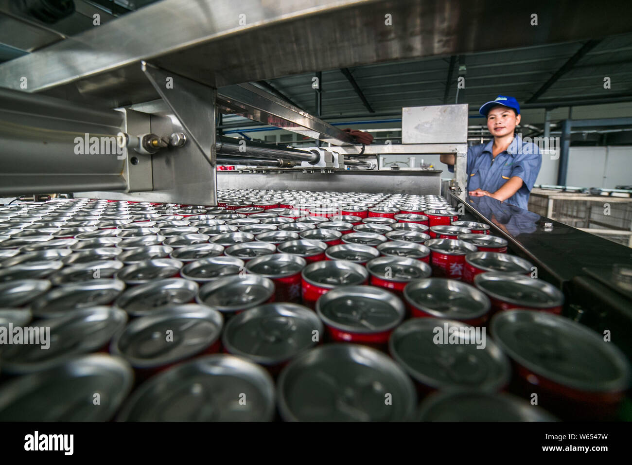 --FILE--A Chinese worker surveys the production of beverage on the ...