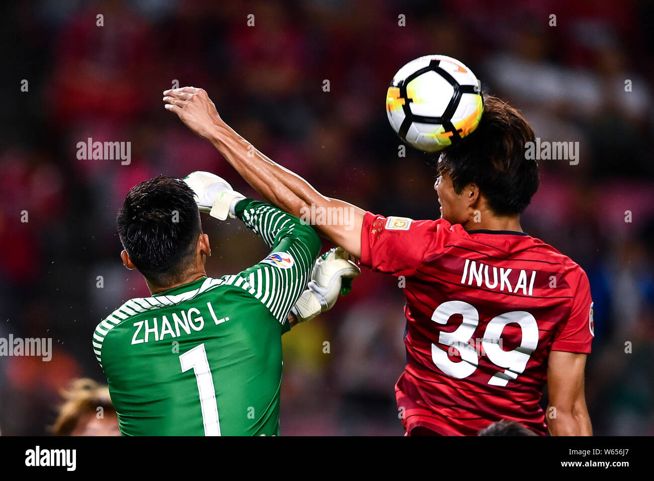 Tomoya Inukai, right, of Japan's Kashima Antlers challenges Zhang Lu of