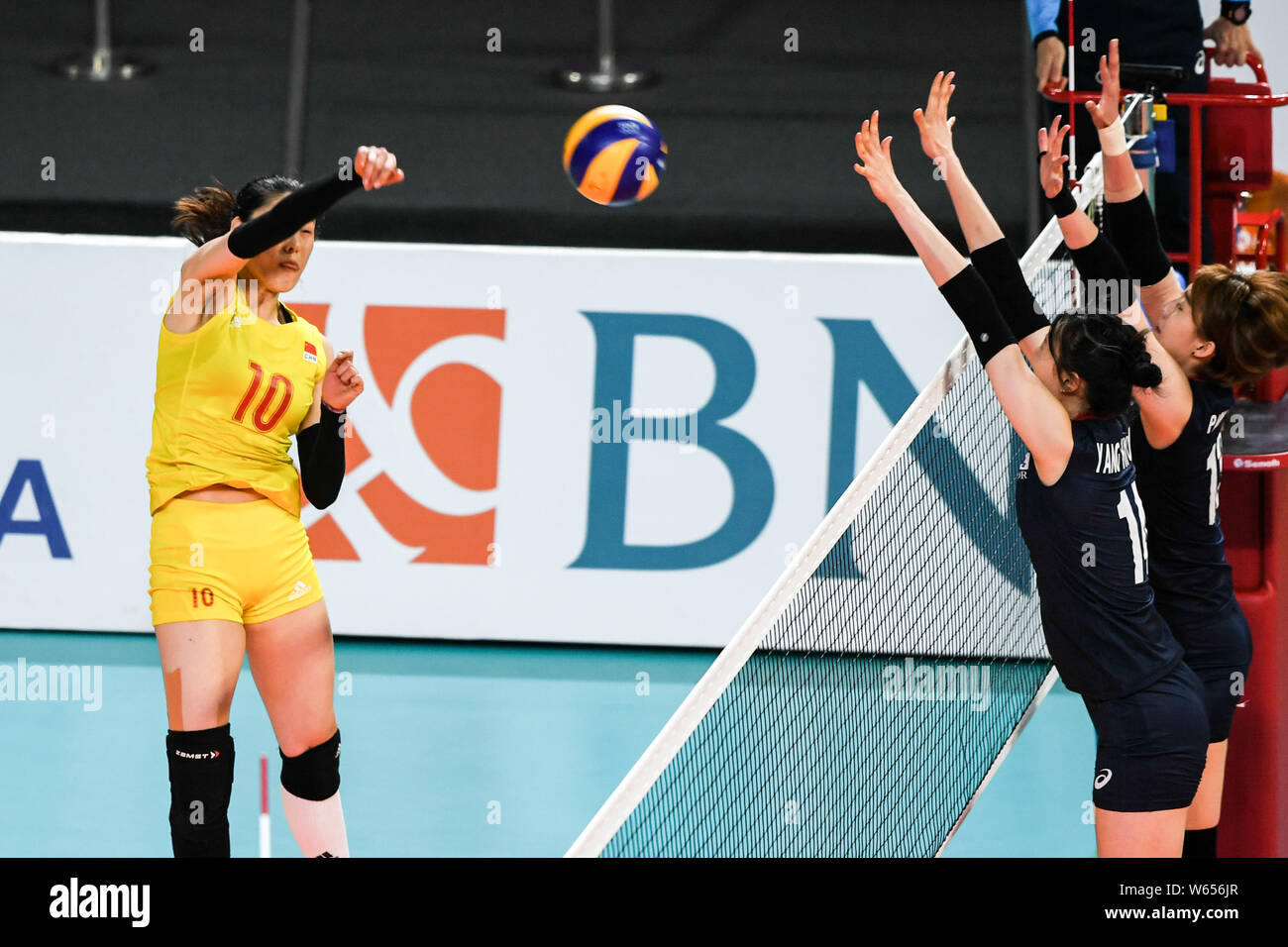 Liu Xiaotong of China, left, spikes against players of South Korea in ...