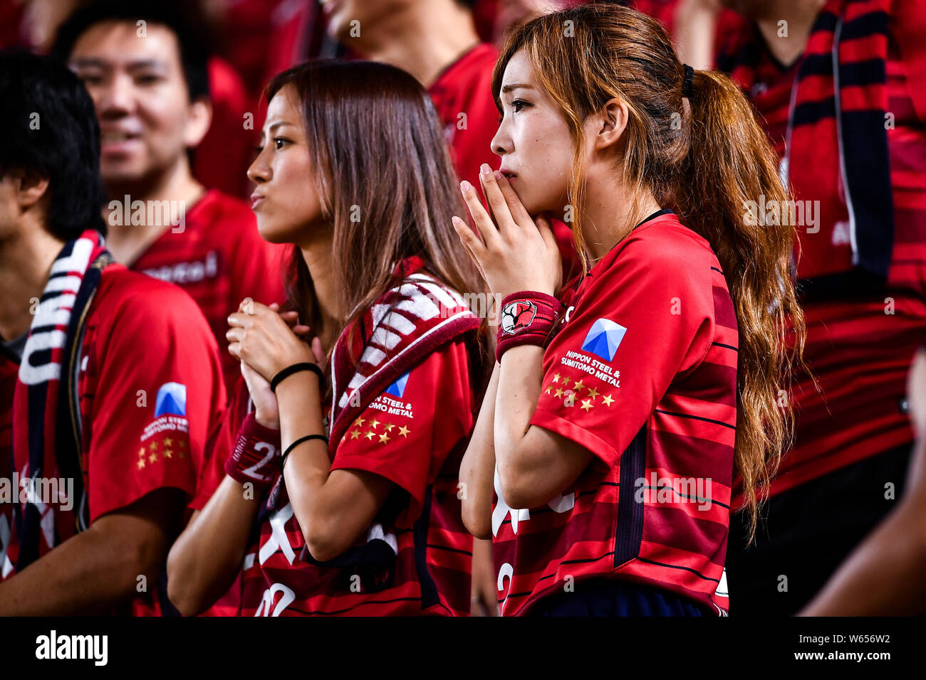 Football fans wave flags and shout slogans to show support