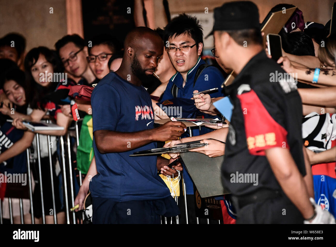 Lassana Diarra signs autographs for fans as he and teammates of Paris Saint-Germain leave the hotel for an event for Trophee des Champions 2018 in She Stock Photo