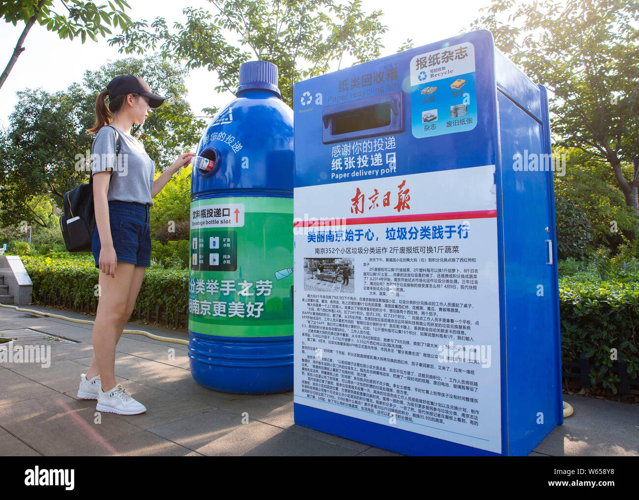 A woman throws a bottle into a bottleshaped recycling bin installed near the Jiming Temple