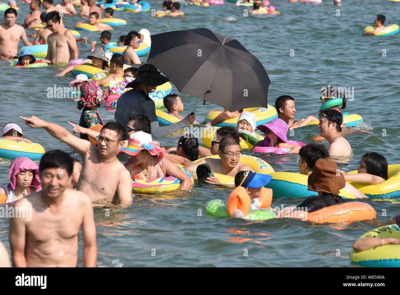 Holidaymakers crowd a beach resort to cool off on a scorching day after 'Liqiu,' meaning the start of autumn, one of the traditional 24 solar terms, i Stock Photo