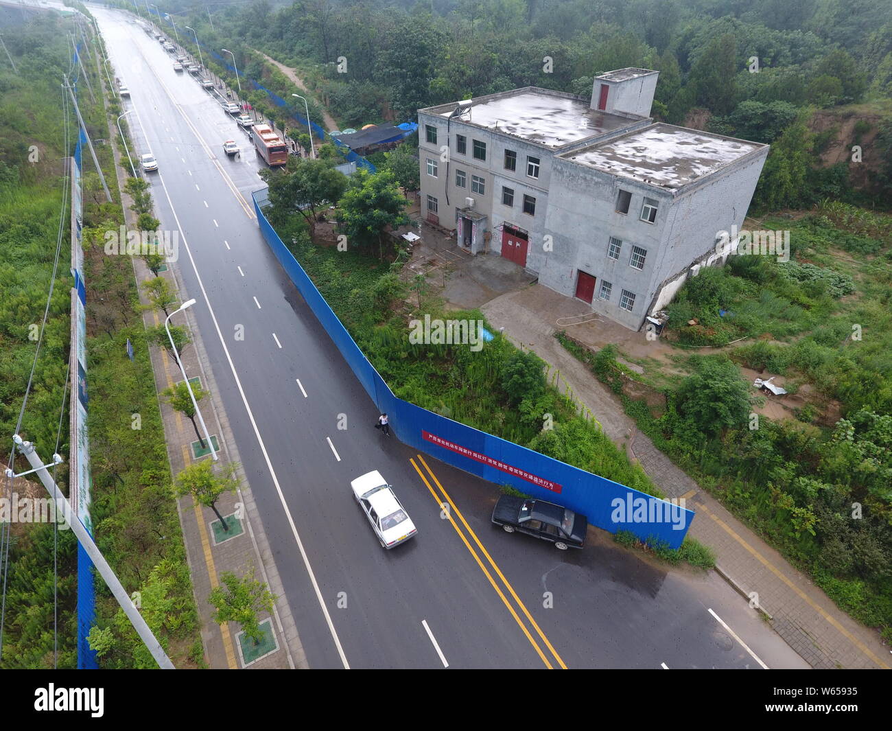 Aerial view of the nail house chopping off a road as house owners
