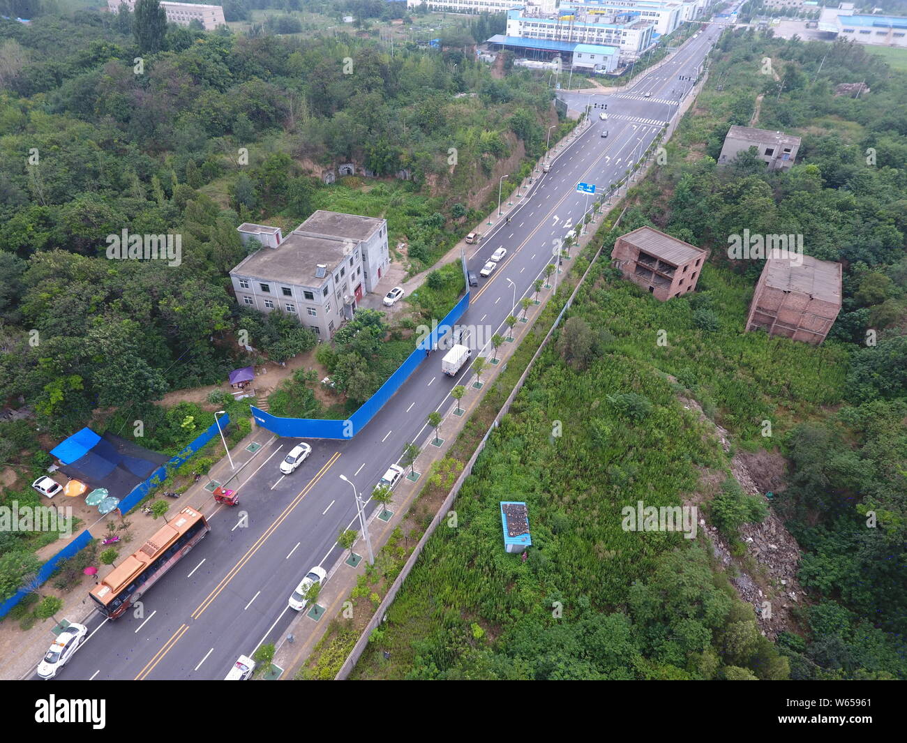 Aerial view of the nail house chopping off a road as house owners