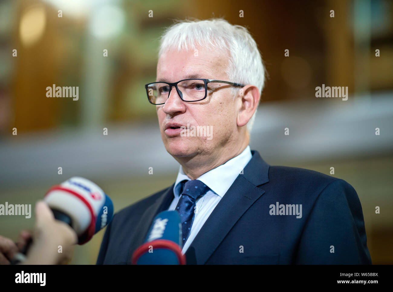 31 July 2019, North Rhine-Westphalia, Münster: Jürgen Resch, Managing Director of Deutsche Umwelthilfe, gives an interview before the hearing. The Higher Administrative Court of North Rhine-Westphalia is hearing the action brought by Deutsche Umwelthilfe (German Environmental Aid) against the city of Aachen for the continuation of the Cologne district government's air pollution control plans. The aim is to take measures to ensure that the limit values for nitrogen dioxide are complied with as quickly as possible. Photo: Guido Kirchner/dpa Stock Photo