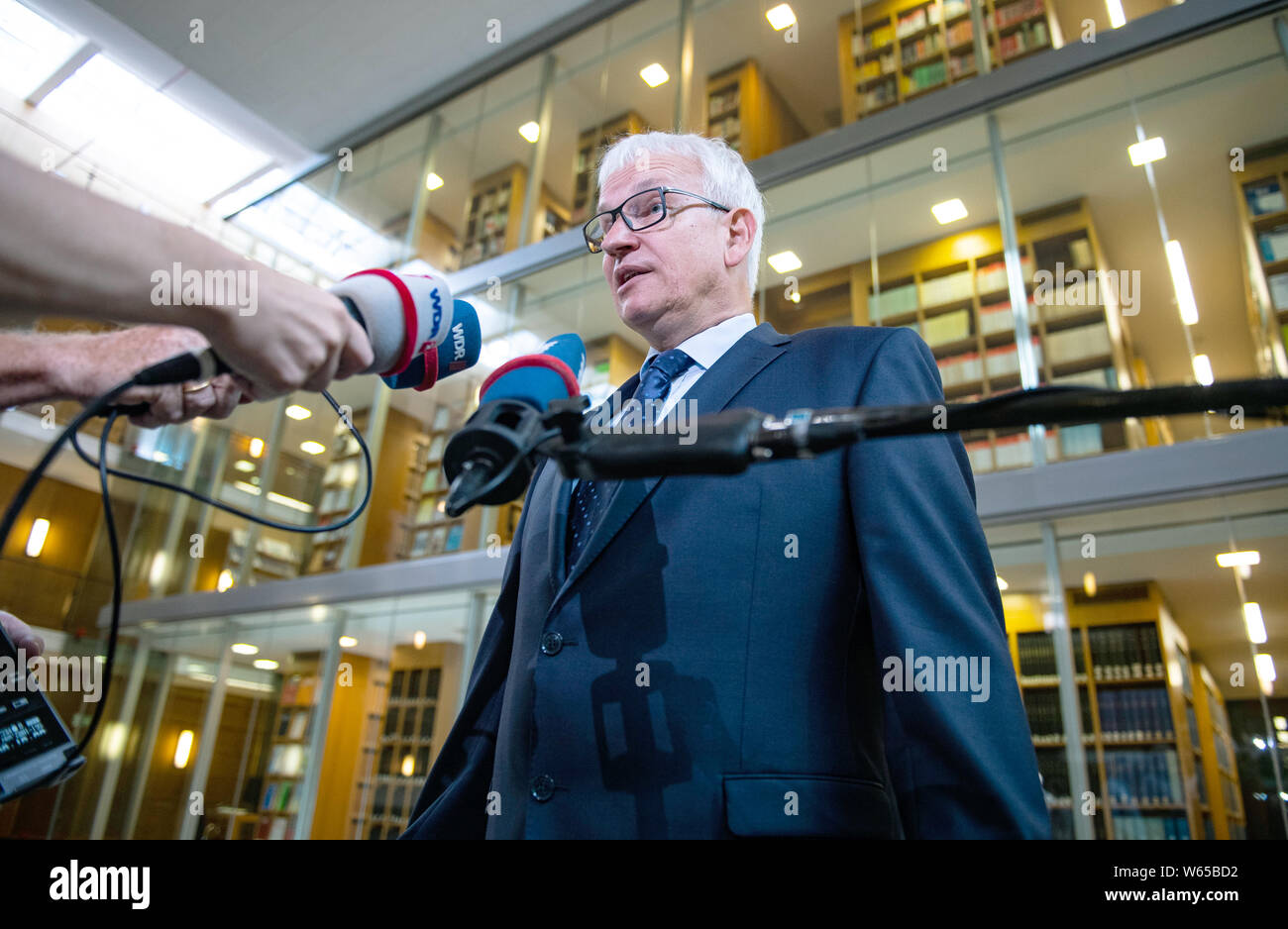 31 July 2019, North Rhine-Westphalia, Münster: Jürgen Resch, Managing Director of Deutsche Umwelthilfe, gives an interview before the hearing. The Higher Administrative Court of North Rhine-Westphalia is hearing the action brought by Deutsche Umwelthilfe (German Environmental Aid) against the city of Aachen for the continuation of the Cologne district government's air pollution control plans. The aim is to take measures to ensure that the limit values for nitrogen dioxide are complied with as quickly as possible. Photo: Guido Kirchner/dpa Stock Photo