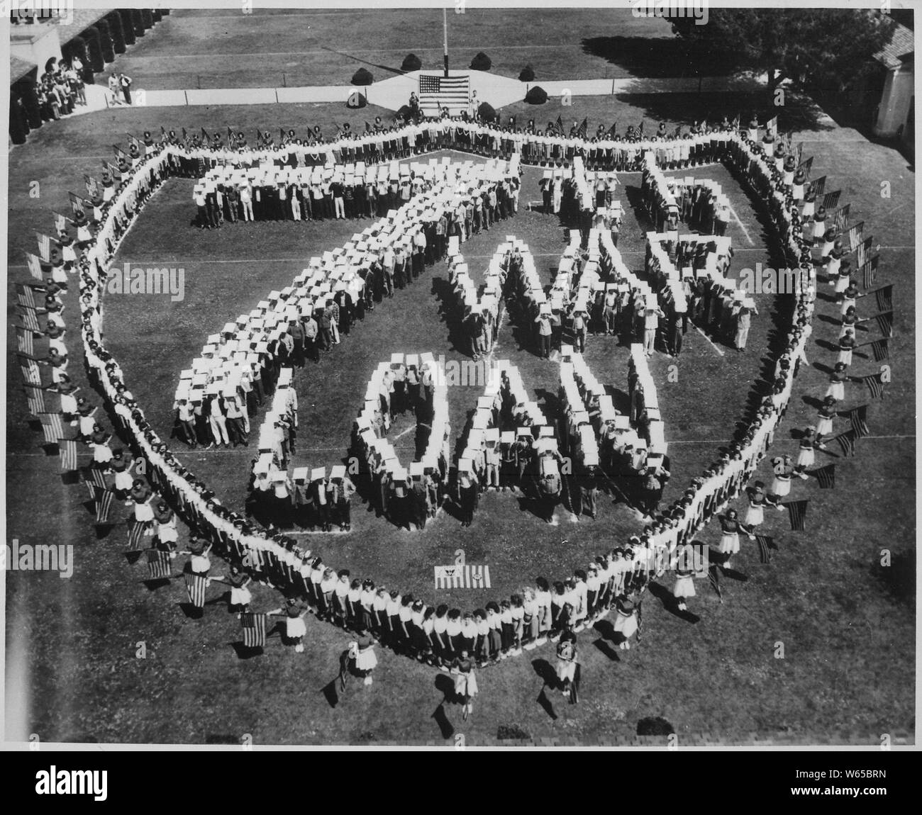 Forming a U.S. Coast Guard shield, high school students at Long Beach, California make a striking appeal for the support of the current 7th War Loan drive, in which every purchase of a war bond helps to land that knockout blow against the Japanese., ca. 1945; General notes:  Use War and Conflict Number 770 when ordering a reproduction or requesting information about this image. Stock Photo