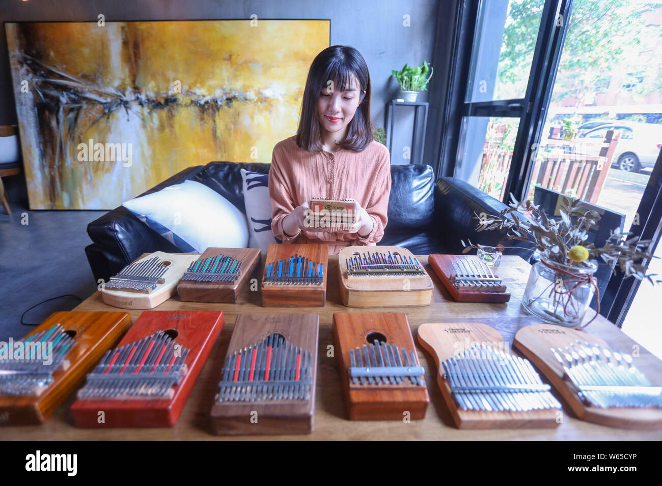 Chinese music lover April Yang poses for photos with redesigned kalimbas, or thumb pianos, at a workshop in Jiaxing city, east China's Zhejiang provin Stock Photo
