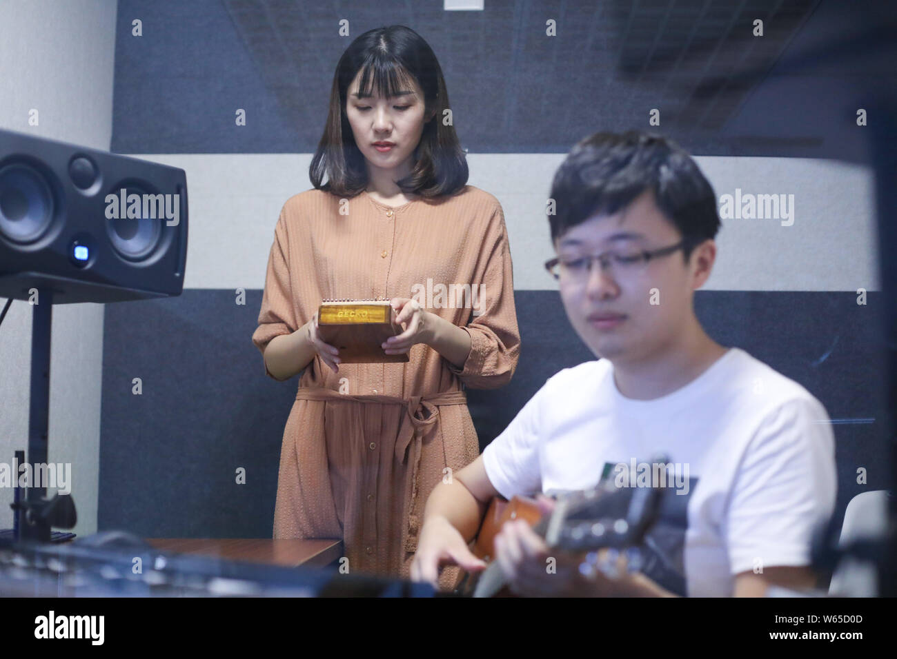 Chinese music lover April Yang plays a redesigned kalimba, or thumb piano, with her guitarist at a workshop in Jiaxing city, east China's Zhejiang pro Stock Photo
