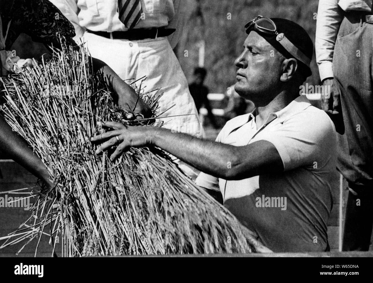 Pontine reclamation service, benito mussolini during the threshing of wheat in sabaudia, 1934 Stock Photo