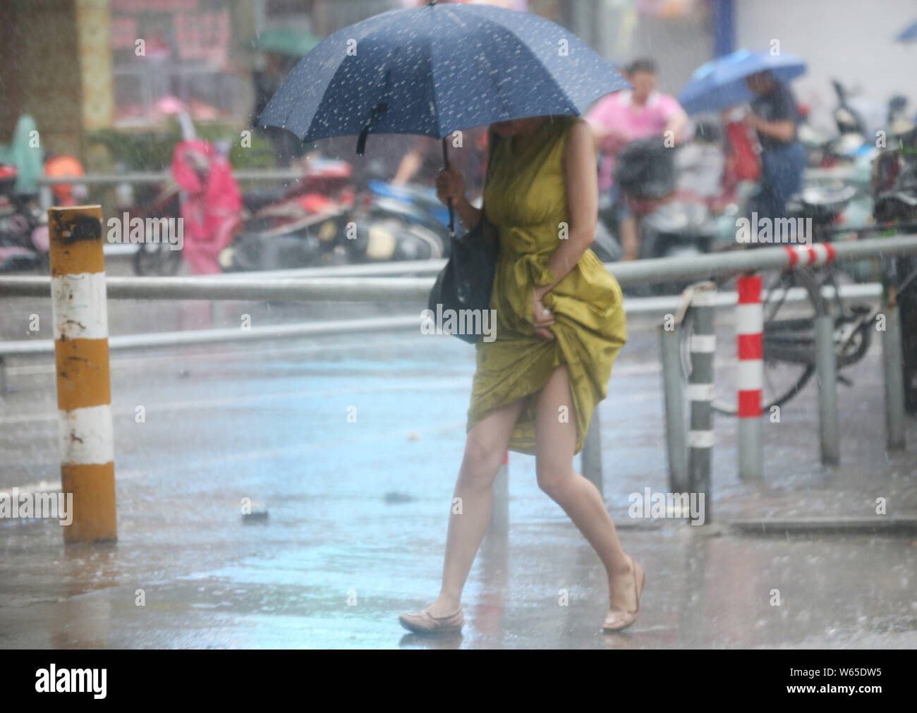 A pedestrian shielding herself with an umbrella braves strong wind and heavy downpour caused by Typhoon Rumbia, the 18th typhoon of the year, in Nanto Stock Photo