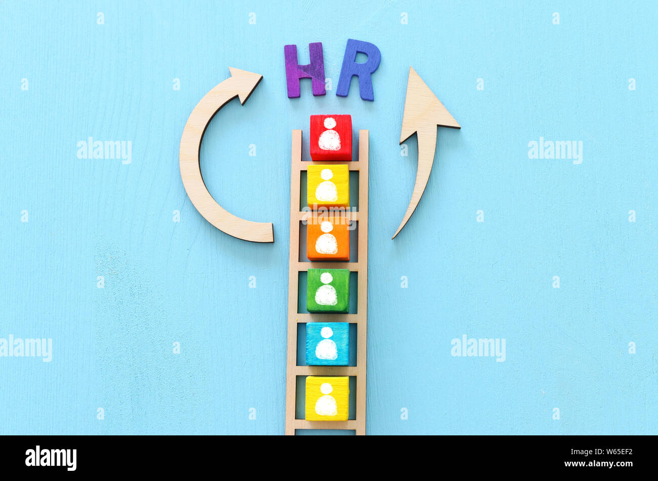 Business image of wooden ladder with people icons over blue table ...