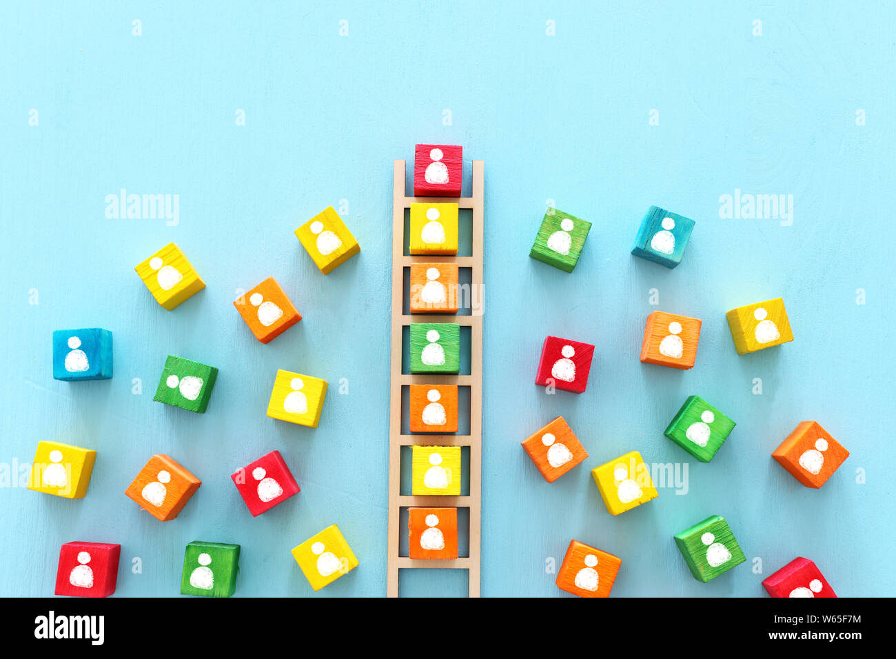 Business image of wooden ladder with people icons over blue table ...