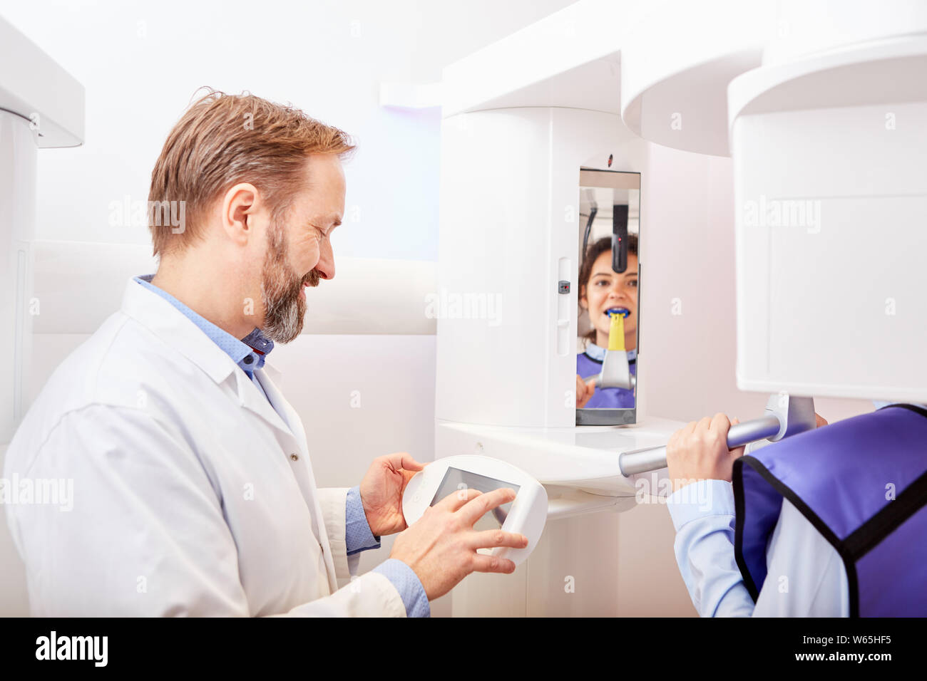 Dentist operates the Xray device for Xray diagnostics in the dental clinic or doctor's office