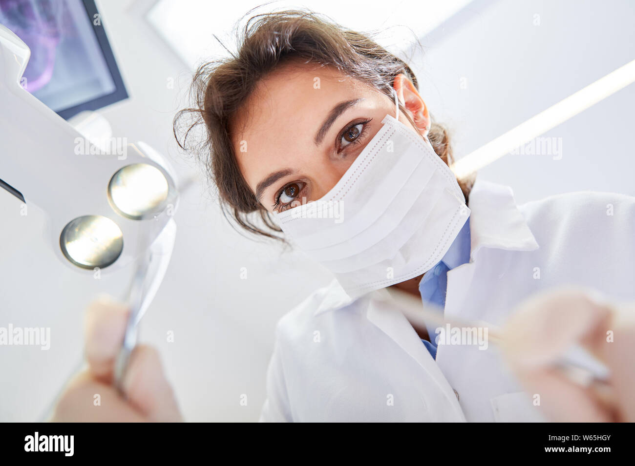 Young woman wearing surgical mask as a dentist or dental assistant in training Stock Photo