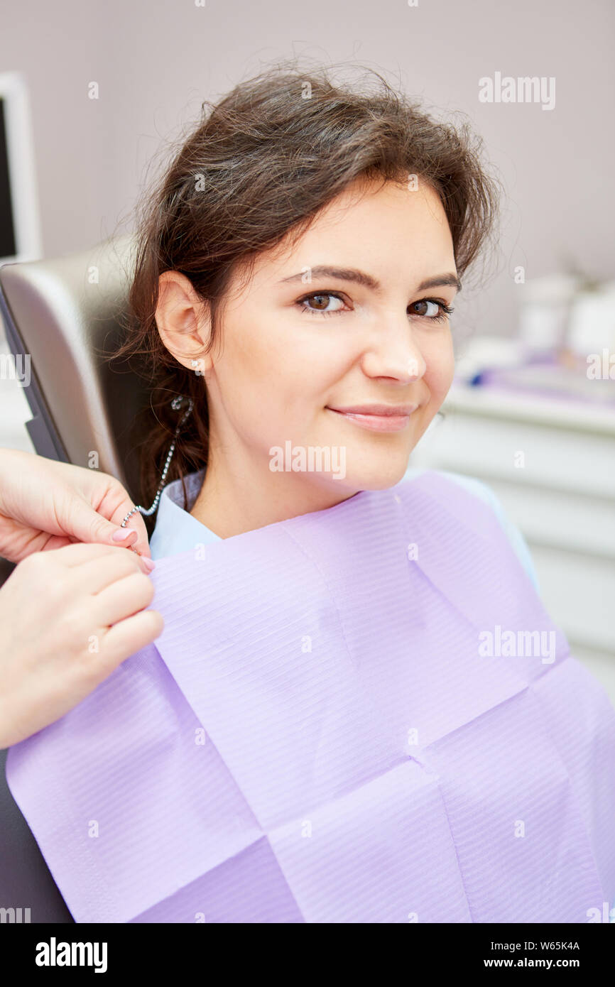 Young woman as a patient waits uncertainly for examination in the chair at the dentist Stock Photo