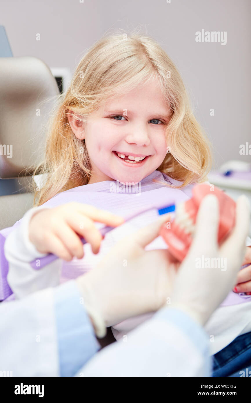 Child learns to brush teeth as a precaution for dental health with a