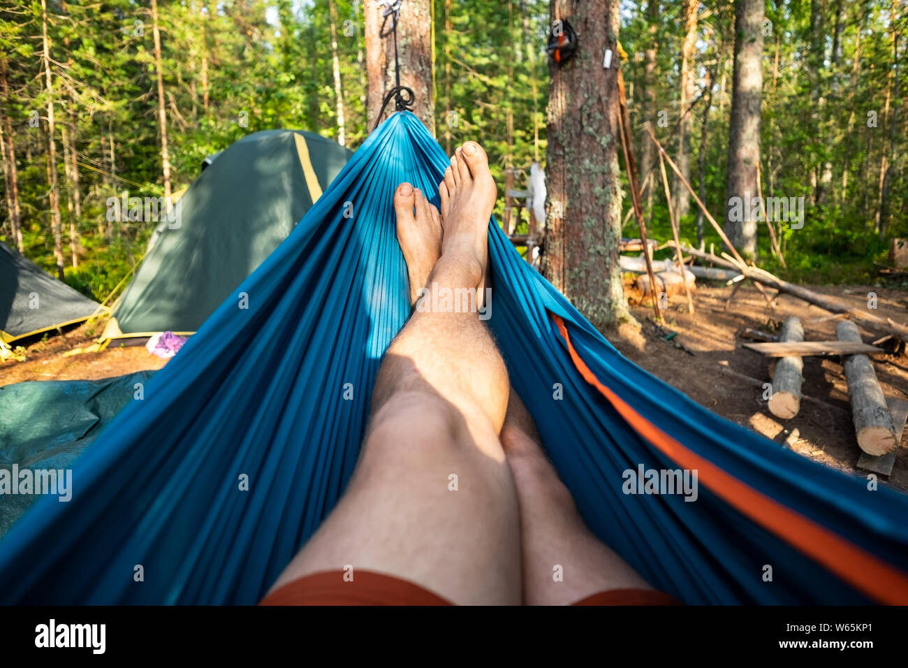 Man resting in a hammock on a summer day during vacation. Stock Photo