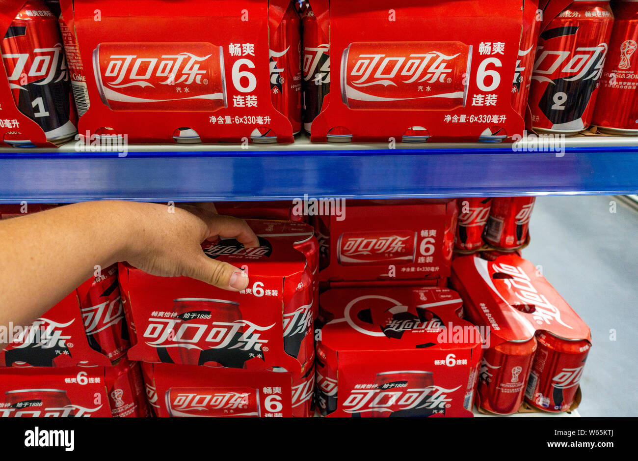 --FILE--A customer shops for tins of Coca-Cola coke at a supermarket in Shanghai, China, 12 June 2018.   US soda and beer lovers might want to start s Stock Photo