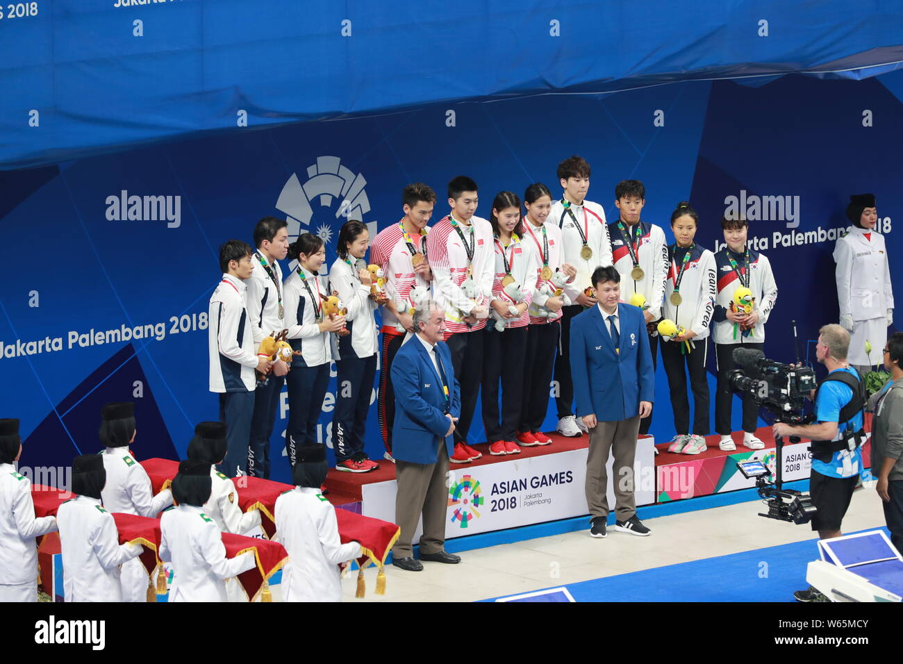 Gold medalist China's mixed 4x100 medley relay team, center, pose at