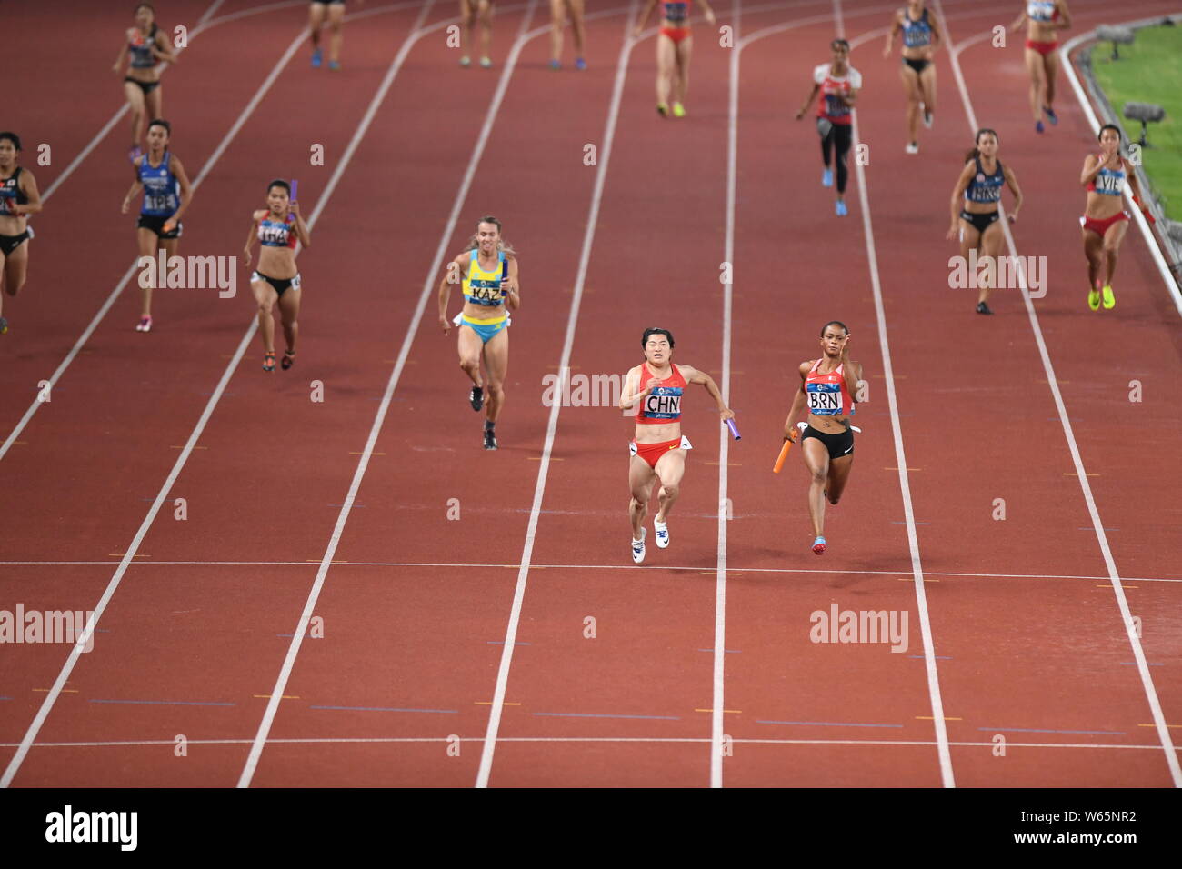 Salwa Naser of Bahrain, right, and other players compete in the women's 4x100m relay final of the athletics competition during the 2018 Asian Games, o Stock Photo
