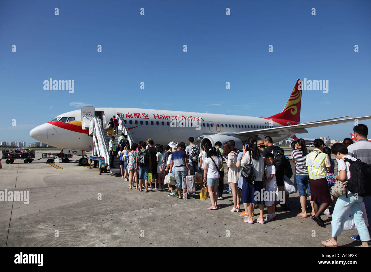 FILE--Passengers board a jet plane of Hainan Airlines of HNA Group at the  Sanya Phoenix International Airport in Sanya city, south China's Hainan pr  Stock Photo - Alamy