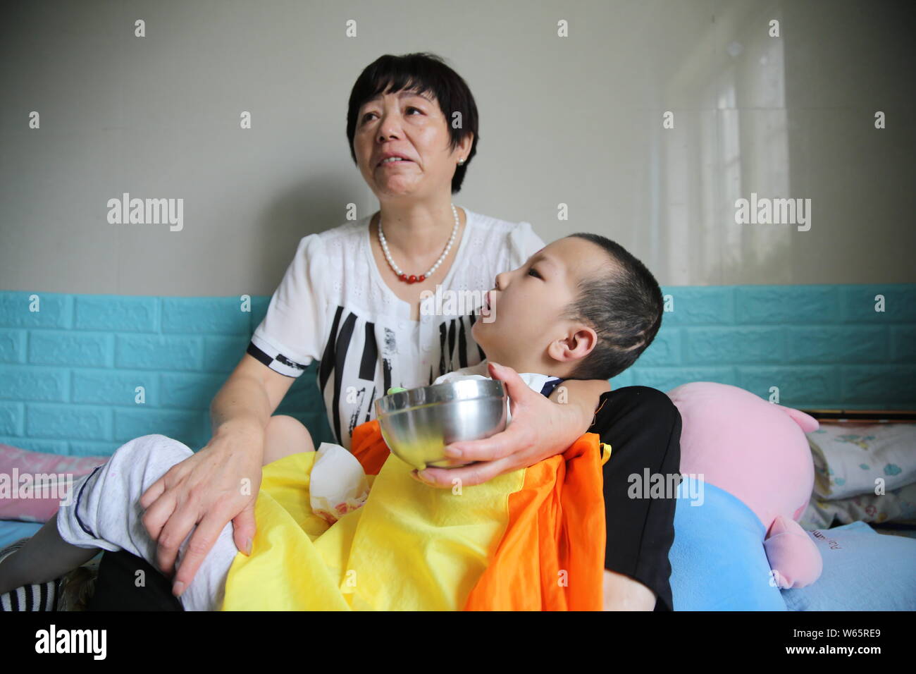 Chinese care worker Zhang Xia looks after the 7-year-old boy Peng Peng who was seriously injured due to his stepmother's cruel treatment at a hospital Stock Photo