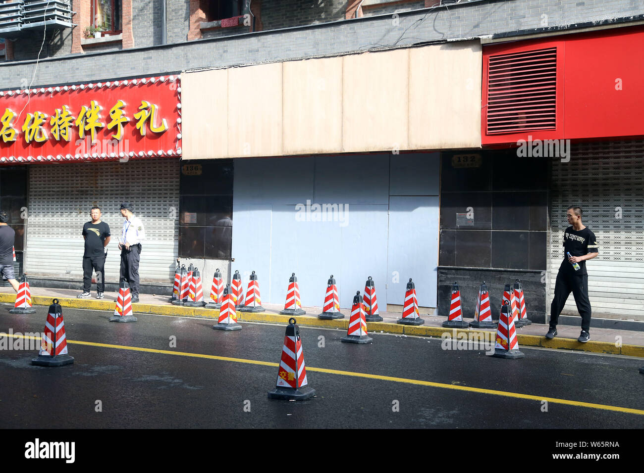 Security guards set up a cordoned-off area in front of the souvenir shop after its signboard collapsed, killing 3 people and injuring 6 others, on Eas Stock Photo