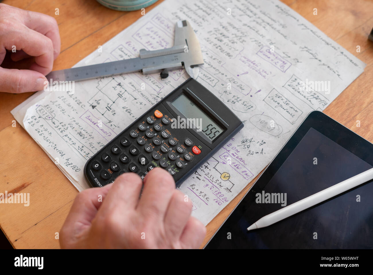 old man doing some math calculations using digital calculator at his work  place Stock Photo - Alamy