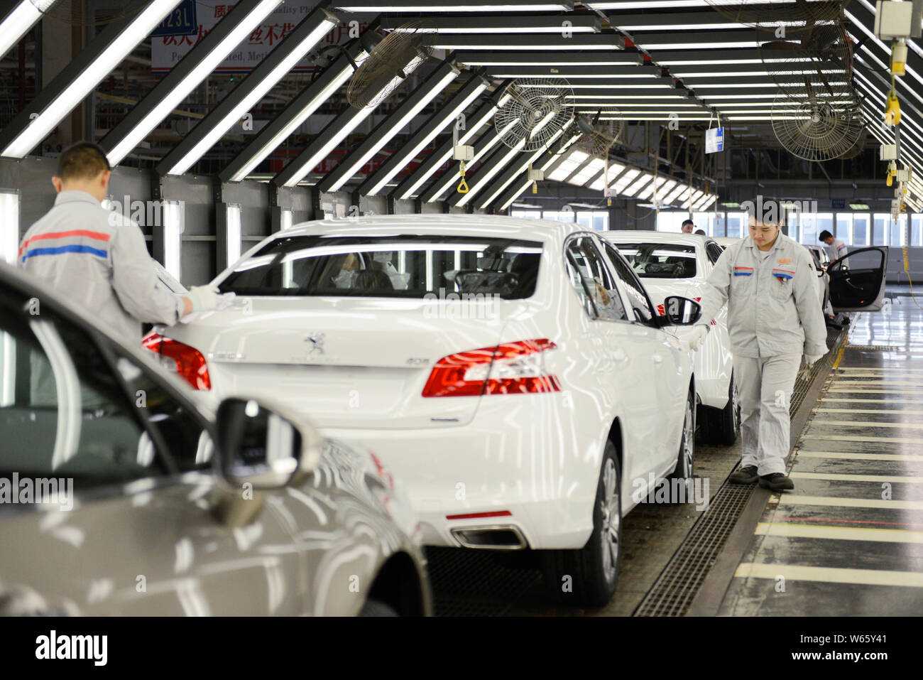 A Chinese worker assembles Peugeot 508 on the assembly line at an auto ...
