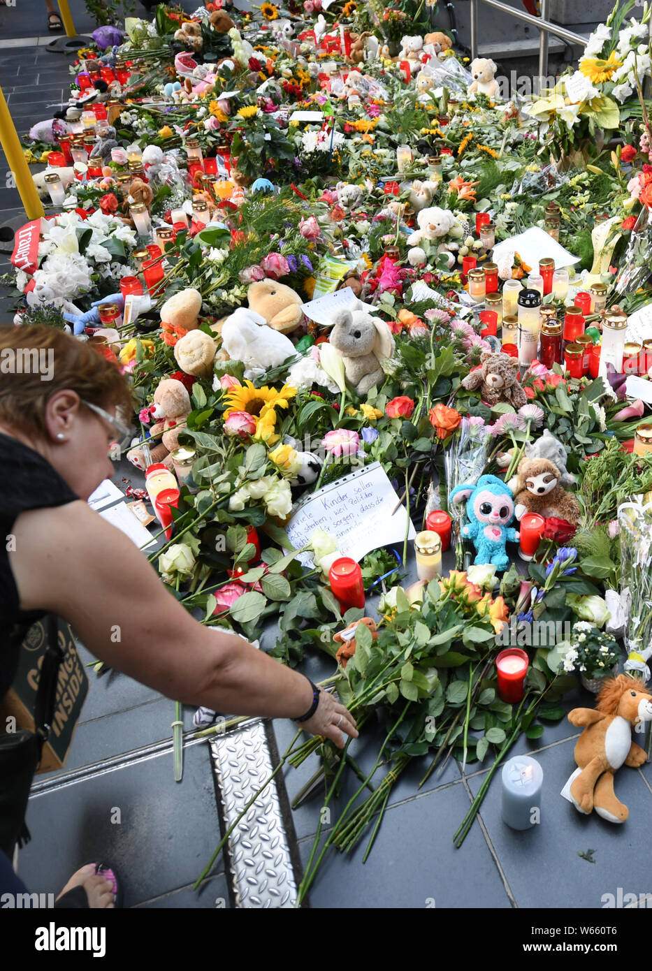 31 July 2019, Hessen, Frankfurt/Main: A woman is laying flowers on track 7 of the main station. An eight-year-old boy was pushed and killed here on 29 July by a man in front of an ICE train. Photo: Arne Dedert/dpa Stock Photo