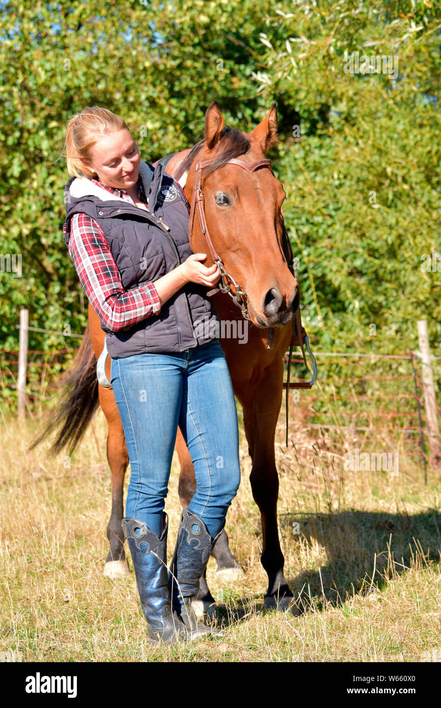Young Woman and American Quarter Horse, bay, western horse, gelding Stock Photo