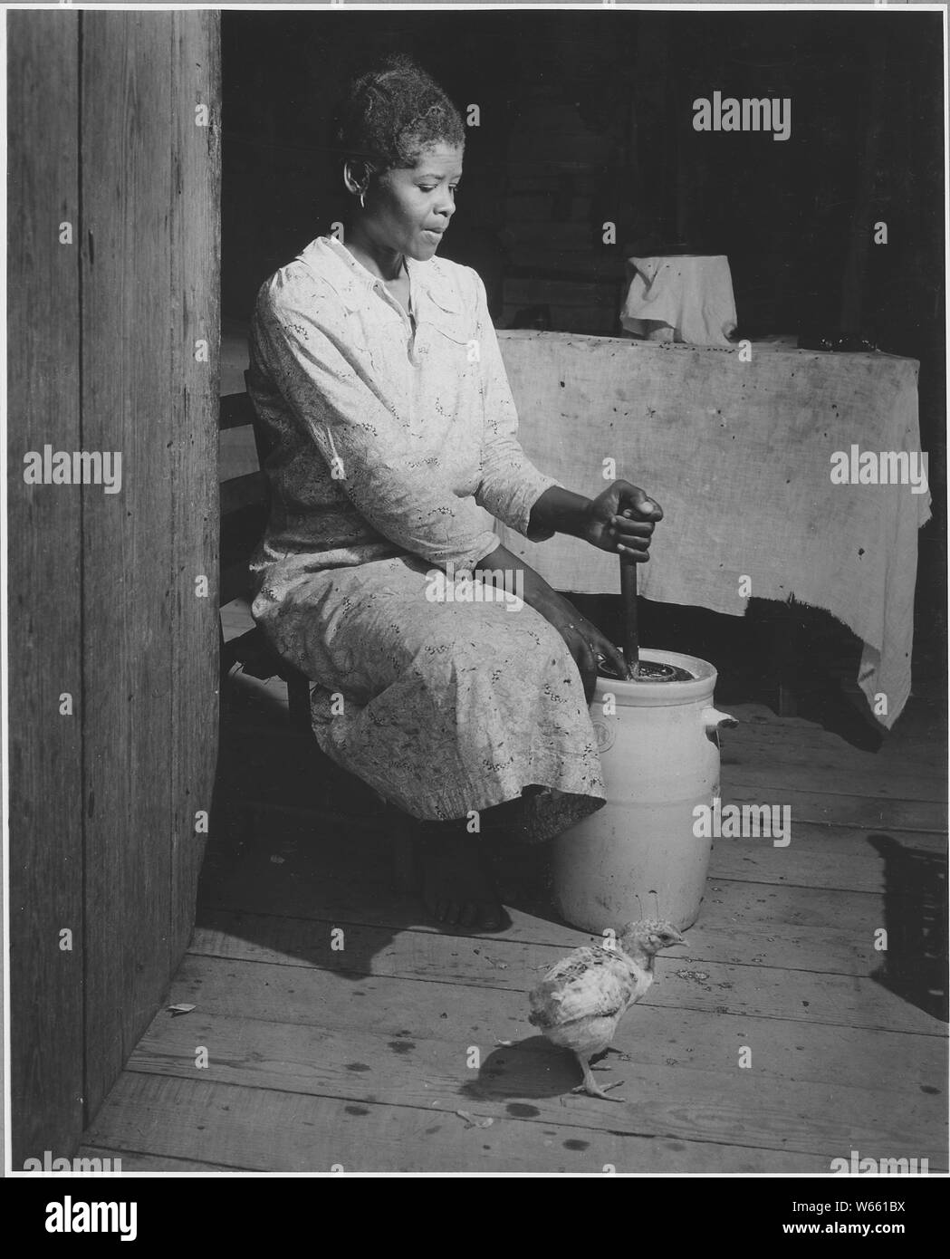 Harmony Community, Putnam County, Georgia.... These pictures show another tenant's place. There is a . . .; Scope and content:  Full caption reads as follows: Harmony Community, Putnam County, Georgia.... These pictures show another tenant's place. There is an organ here too.... [An African-American woman] making butter. Stock Photo