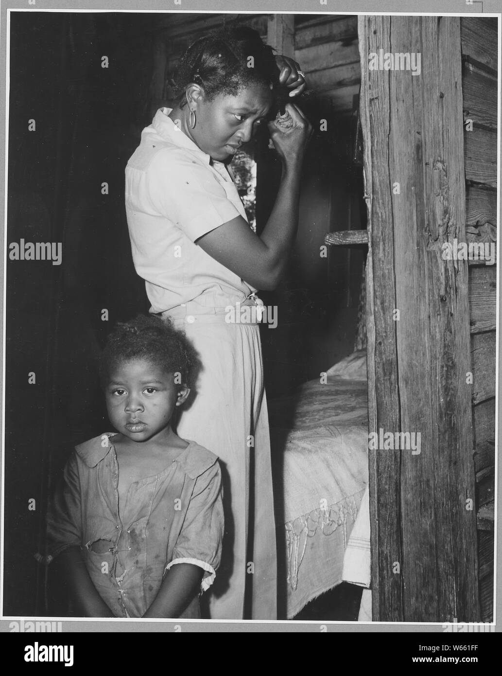 Harmony Community, Putnam County, Georgia.... These pictures show another tenant's place. There is a . . .; Scope and content:  Full caption reads as follows: Harmony Community, Putnam County, Georgia.... These pictures show another tenant's place. There is an organ here too. ...[An African-American woman and child] fixing up to go to town on Saturday afternoon. Stock Photo