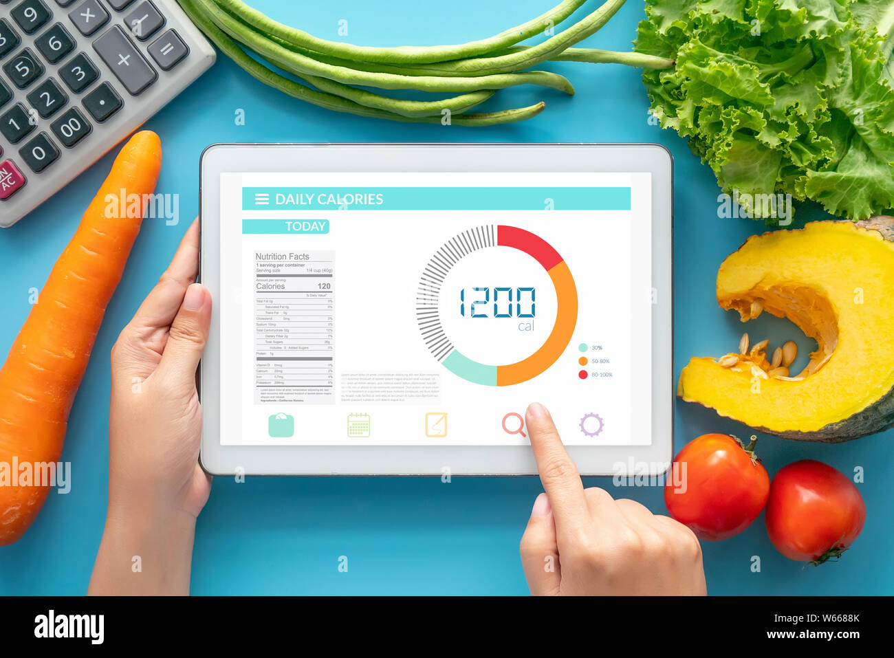 Calories counting , diet , food control and weight loss concept. woman using Calorie counter application on tablet at dining table with fresh vegetabl Stock Photo