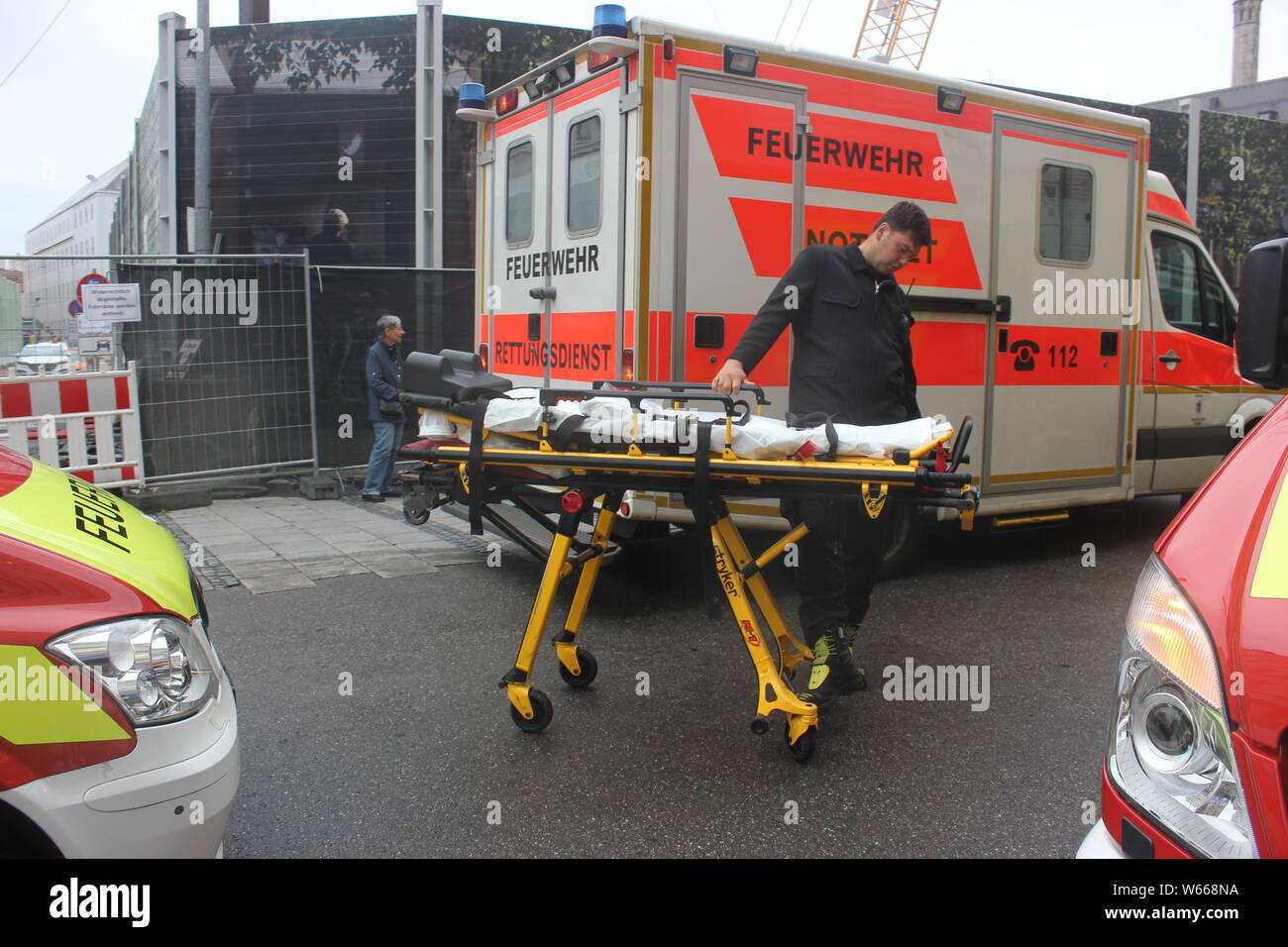 Wheel stretcher, ambulance van, fire ambulance truck, group of ambulance vans. Rollable stretcher, Germany, pedestrian area Munich. Stock Photo