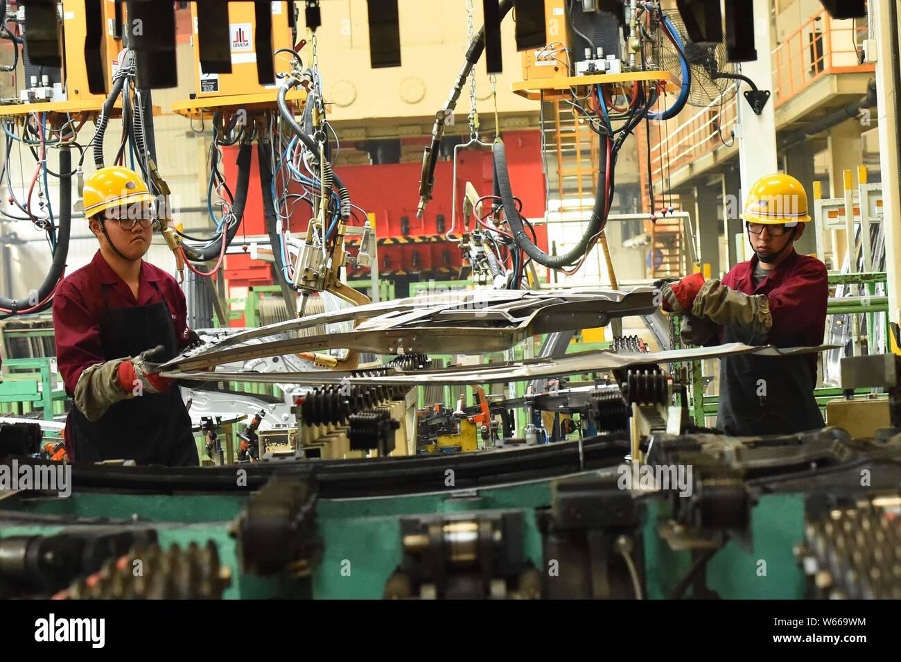 --FILE--Chinese workers assemble a truck on the assembly line at the ...
