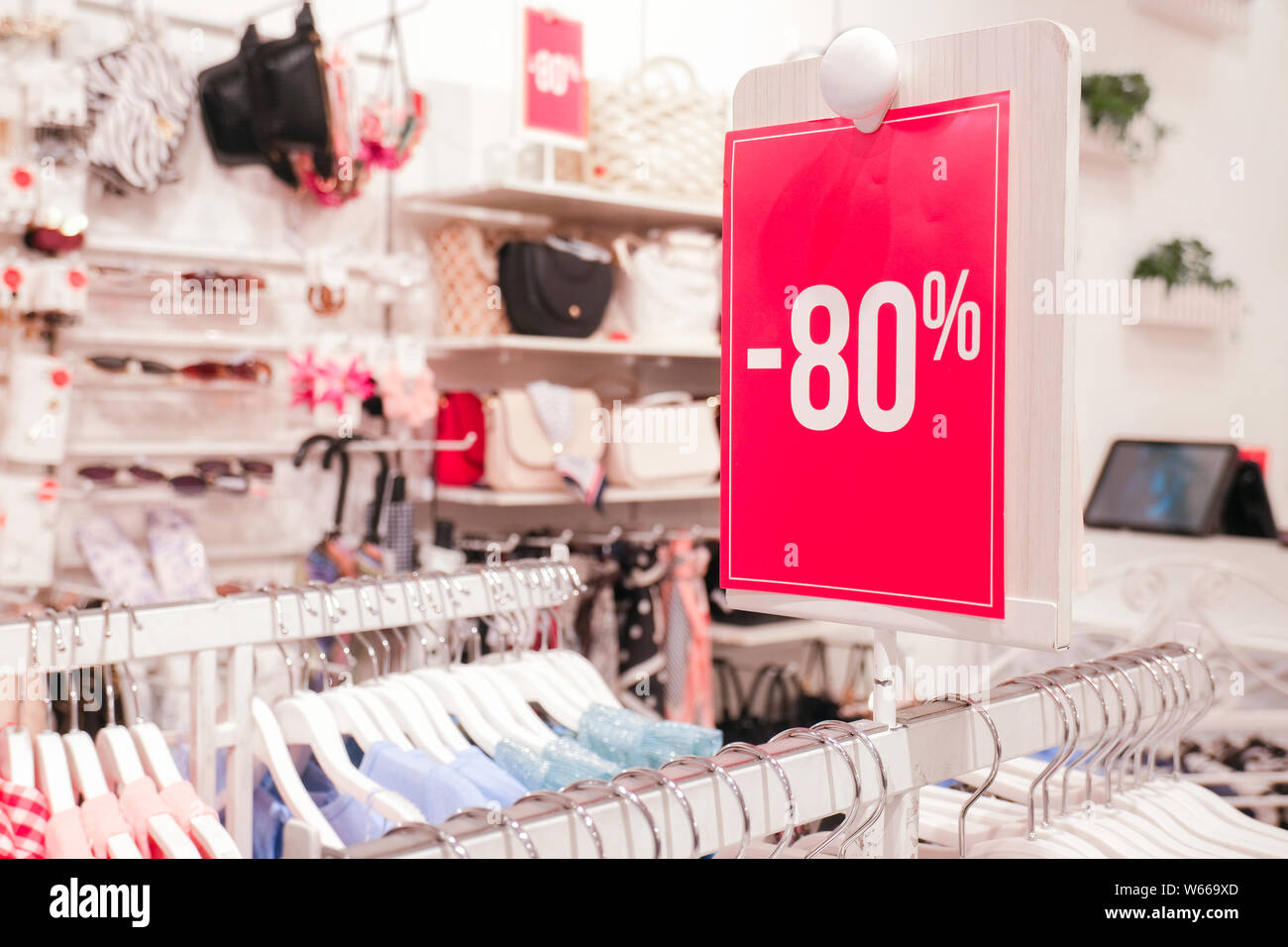 Season sale, black friday and shopping concept. Red stand 80 percent discount price in shop. Clothes hangers on background. Stock Photo