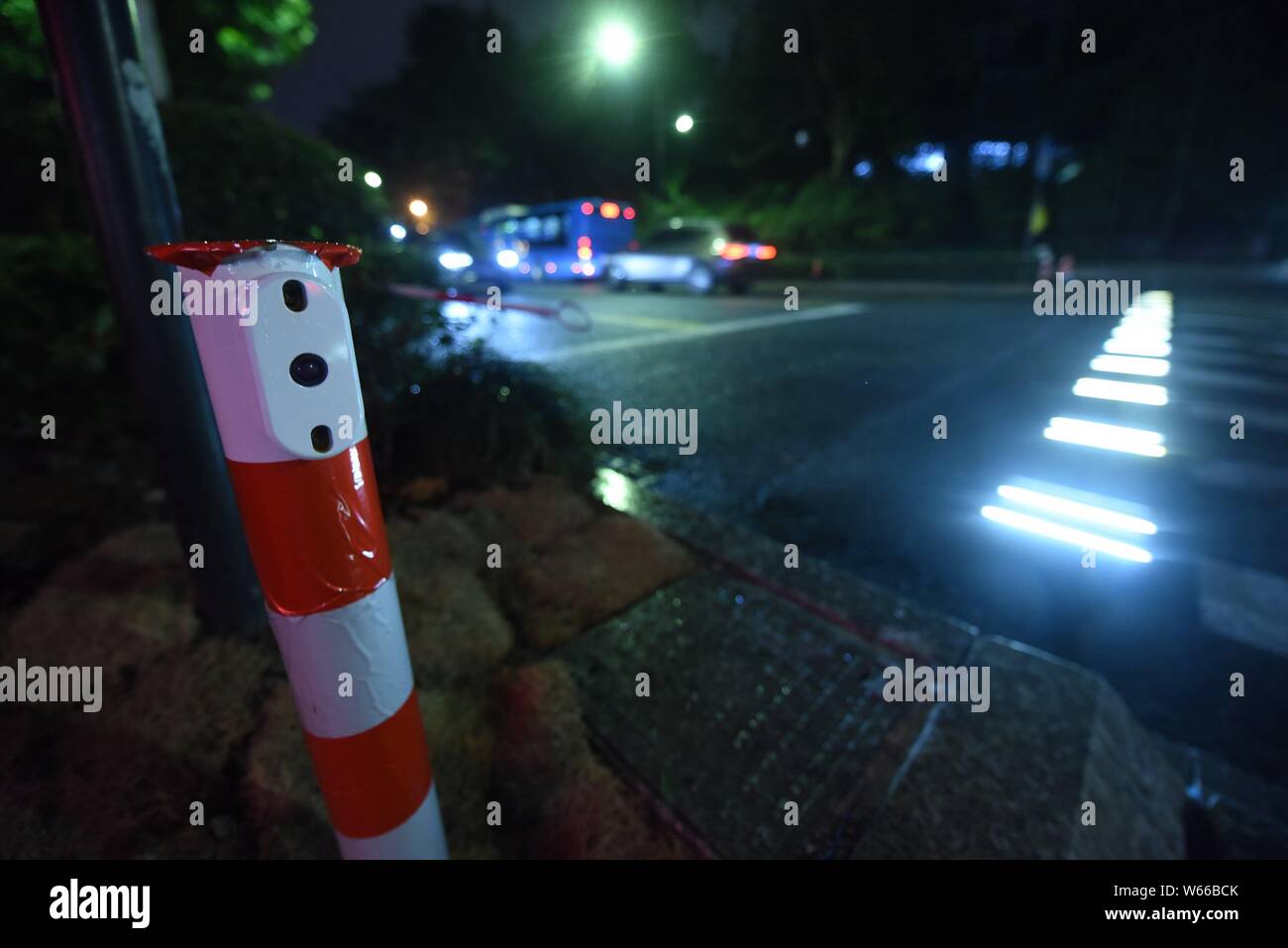 Pedestrians walk on an intelligent zebra crossing as the lights