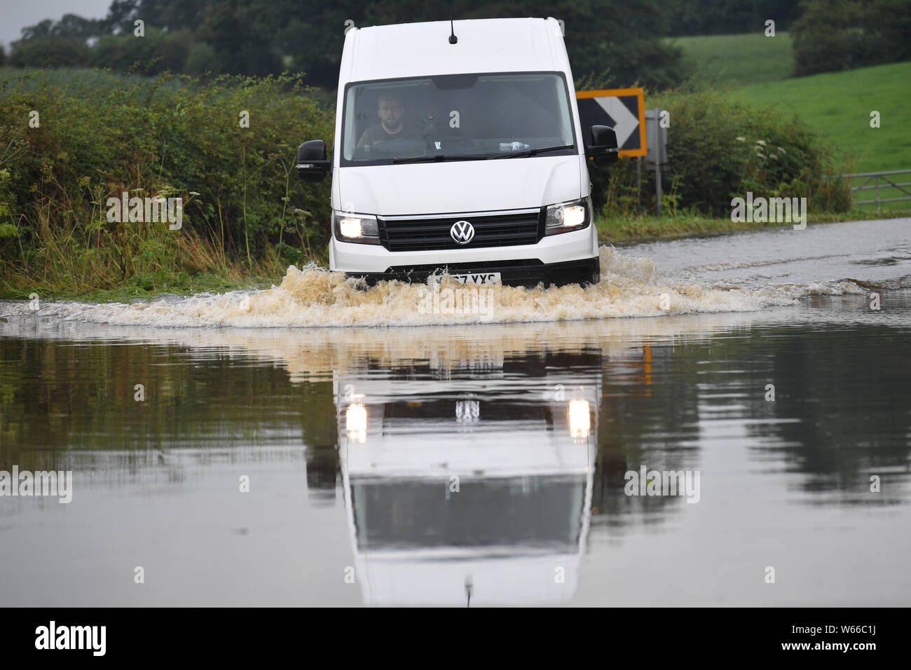 A van makes its way along the flooded Bonis Hall Lane, Cheshire, after